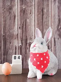 复活节兔子和兔子蛋，日历上的棕色木制背景与复制空间。节日的概念。