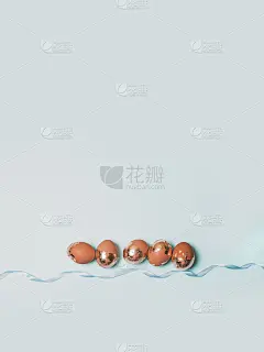 节日复活节金色和青铜蛋在蓝色的背景。春天的贺卡。平躺，俯视图。