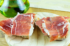 木盘子上放着几片新鲜火腿的三明治。快地中海的零食。