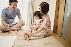 Baby girl playing with family in homeHappy family having a good time with baby girl