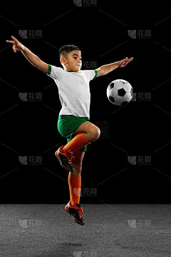 男孩的全身肖像，孩子，足球运动员在统一训练孤立在黑色背景。