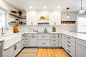 Kitchen - country u-shaped medium tone wood floor and brown floor kitchen idea in Salt Lake City with a farmhouse sink, shaker cabinets, granite countertops, white backsplash, gray cabinets, stainless steel appliances, a peninsula and white countertops