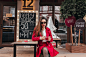 Lovely girl wears sunglasses and red skirt sitting in outdoor cafe