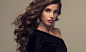 Young attractive brunette with voluminous, shiny and curly hairstyle.