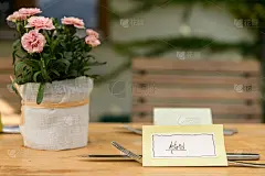 木制桌上有手写的餐桌名片和餐具