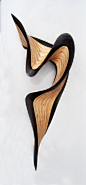 Wood Wall Art - This wood sculpture ripples across the wall with a flourish. The artist hand cuts layers of Baltic birch and wenge wood, then meticulously stacks and glues them together before carving and sanding them into the final form. The piece has a 