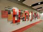 This may contain: a wall with many pictures on it in an office building that is decorated with red carpet and white walls