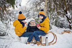 可爱的兄弟姐妹们，孩子们在雪地里开冬季派对。年轻的兄弟们，男孩子们，用保温瓶喝茶。热饮和冷饮