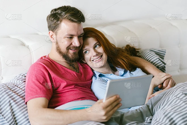 年轻夫妇在家里放松和使用平板电脑。