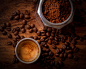 brown coffee beans beside white ceramic mug