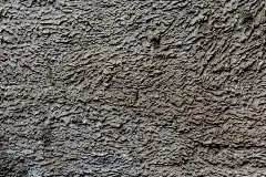 背景为灰色灰泥涂布和外表面涂漆，粗糙浇筑水泥和混凝土墙面纹理，装饰性涂料