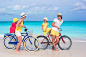 Young family of four riding bicycles on a tropical sand beach by Dmitry Travnikov on 500px