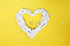 黄色背景上的白色藤心。快乐的一天，爱情，早上好概念。平的风格。
