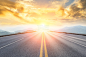 asphalt road and mountains with foggy landscape at sunset