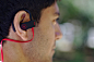 man wearing black and red earloop earphone