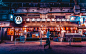 A lone man walking past a restaurant storefront in Tokyo at night