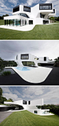 House Exterior Colors - 11 Modern White Houses From Around The World // The curved lines and pops of black against this large white house give it a clean, futuristic look.