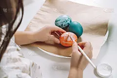 裁剪的肖像小女孩的手，画多色复活节母鸡鸡蛋，棕色的纸盘子桌子，画笔
