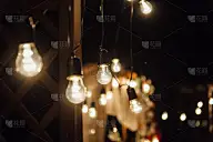 晚上的婚礼。一个灯泡花环。晚上，玻璃烧瓶里的蜡烛。