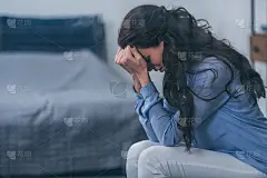 选择性聚焦女性坐在家里哭泣时用手捂脸与拷贝空间