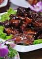 【咖啡排骨】主料：新鲜排骨500克。配料：鸡蛋、淀粉。调料：咖啡豆、吉士粉、草果、陈皮、香叶、八角、桂皮、番茄酱、精盐、味精、鸡精、冰糖、花生油、高汤。（做法：1、将肉排洗净，切成小方块，加入吉士粉、精盐、味精、鸡蛋、淀粉上浆待用。2、热锅下花生油烧至五六成热，放入排骨炸至金黄色，捞起沥油。热锅下高汤，加入现磨的咖啡、草果、陈皮、香叶、八角、桂皮熬成咖啡汁。3、热锅下花生油，放入咖啡汁、番茄酱、冰糖、精盐、味精、高汤，烧沸后放入排骨，煨至熟透，勾芡装盘即可。）