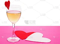 粉红色的桌子上放着玻璃和红纸制成的情人节爱心
