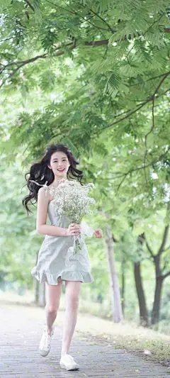 手拿着鲜花奔跑的可爱美女手机壁纸