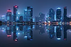 海滨城市夜景下的高楼摄影图