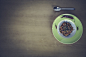 Green and White Ceramic Plate Beside Stainless Steel Spoon on Brown Table