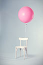 pink balloon tied on white wooden chair