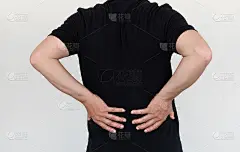 亚洲男士腰痛时，按摩腰部以缓解腰痛。