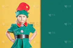 穿着圣诞精灵服装的小女孩。附近的地方，文字在绿色背景，复制空间。美丽的圣诞广告。