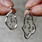 其中可能包括：a person holding a small silver clock in their left hand and another piece of jewelry hanging from the other side
