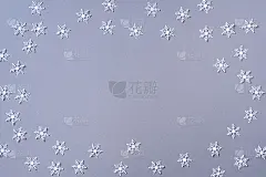 白色雪花在灰色背景上做成的冬季图案。前视图。平的。冬天的作文。圣诞节，新年的概念。