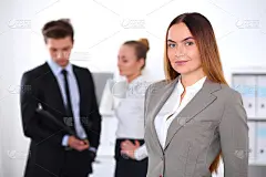 办公室里的漂亮女商人，背后还有同事
