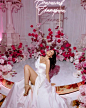 This may contain: a woman sitting on top of a white table covered in pink and red flowers with the word congratulations written above her