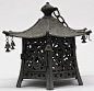 Description: Japanese bronze hanging lantern, of hexagonal form on six supports with openwork side panels including a hinged door, with a wave pattern on the roof, each corner of the roof with a bell, the finial with a handle and linked to an iron chain (
