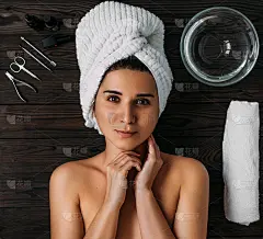 年轻美丽的女人在水疗环境的肖像。女人会照顾自己的身体。女性身体保健。指甲护理，美甲和足疗。头上裹着毛