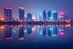 海滨城市夜景下的高楼摄影图