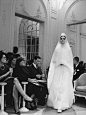 1961年照片 1961年春夏高定系列之“处女”裙。阿根廷模特Kouka Denis穿着Marc Bohan（圣罗兰继任者）设计的结婚礼服在迪奥大厅里走秀。伊夫圣罗兰在1956年挖掘了这名模特，把她当成缪斯女神和品牌代言人。