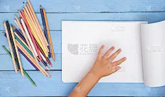 孩子们用铅笔在蓝色桌子上的画册里画画