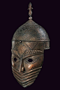 Helmet with hemispherical, iron skull, decorated with engraved cartouches featuring inscriptions in Arabic surrounded by woven racemes, at the top a lily-shaped cusp with round knot and conical base; at the mask, fixed with rivets, relieved decorations an