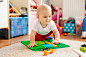 Little baby boy in white t-shirt with a toys on the floor at home Premium Photo