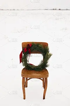 圣诞快乐!冬日雪地里，乡村椅子上的圣诞花环。在农村过寒假。空间的文本。时髦的圣诞花环，松枝和红色的弓