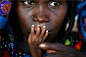  2005，在紧急供给中心，营养不良的Alassa Galisou将手指按在他母亲Fatou Ousseini的嘴唇上。近期最严重的一次干旱，加上蝗虫灾害摧毁上一年的作物收成，造成数百万人食物极度短缺。

