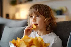 享受美食吃薯片的小孩
