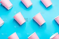 图案从粉红色的纸杯对角线安排在薄荷蓝色的背景。生日派对庆祝抽象时尚宝宝淋浴概念。柔和的颜色。极简风格