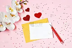 白色兰花花，信封和红色的心与纸屑，笔在粉红色的背景。情人节，母亲节贺卡。复制空间，平放，顶视图。