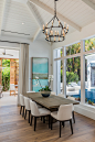 Design ideas for a large coastal dining room in Miami with white walls, marble flooring and beige floors.