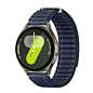 A green Galaxy Watch7 with a navy Fabric band at a tilted angle is shown.